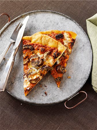 Two Slices of Mushroom Pizza with a Fork and Knife Foto de stock - Sin royalties Premium, Código: 659-07026837