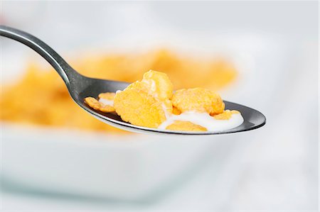 A spoon of cornflakes with milk (close-up) Stock Photo - Premium Royalty-Free, Code: 659-07026974