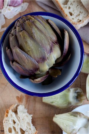 A cooked artichoke in a bowl with bread (view from above) Foto de stock - Sin royalties Premium, Código: 659-07026978