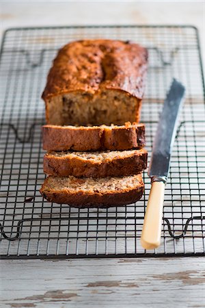 Banana and walnut bread, partly sliced, on a cooling rack Foto de stock - Sin royalties Premium, Código: 659-07027014