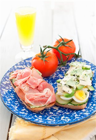 simsearch:659-06155445,k - An Open Ham, Egg, Cucumber and Avocado Sandwich on a Blue and White Plate; Tomatoes Stock Photo - Premium Royalty-Free, Code: 659-07027045