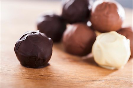 Assorted home-made chocolate truffles on a wooden table Stock Photo - Premium Royalty-Free, Code: 659-07027117