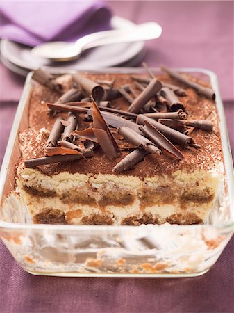 Tiramisu topped with chocolate curls, in a glass dish, part already served Photographie de stock - Premium Libres de Droits, Code: 659-07027195