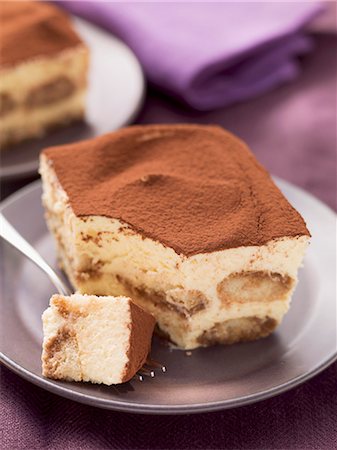 savoiardi - A piece of tiramisu on a plate with a fork Stock Photo - Premium Royalty-Free, Code: 659-07027197