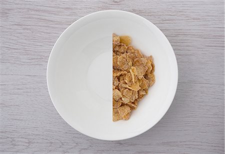 schüssel - A halved portion of cornflakes in a white bowl (view from above) Stockbilder - Premium RF Lizenzfrei, Bildnummer: 659-07027555