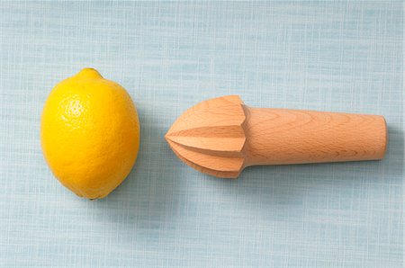 spremiagrumi a mano - A lemon and a lemon squeezer on a wooden surface Fotografie stock - Premium Royalty-Free, Codice: 659-07027938