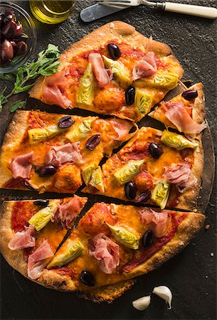 pizza - Pancetta, Artichoke and Olive Pizza; Sliced Fotografie stock - Premium Royalty-Free, Codice: 659-07027989