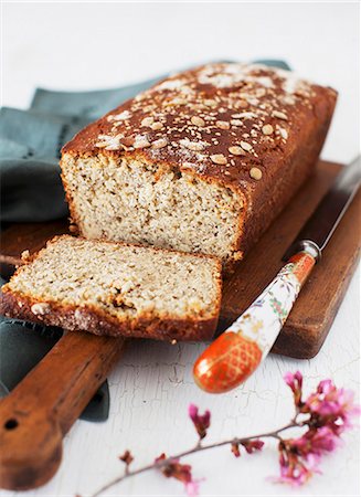 Gluten Free Seeded Honey Bread; Partially Sliced on a Cutting Board Stock Photo - Premium Royalty-Free, Code: 659-07028025