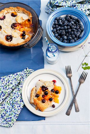 dessert dish - Blueberry and Peach Pie on a Plate and in Baking Dish; Bowl of Fresh Blueberries; Bottle of Milk with a Straw Stock Photo - Premium Royalty-Free, Code: 659-07028029