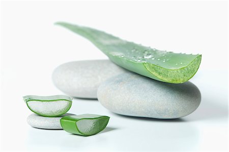 An aloe vera leaf on pebbles Foto de stock - Sin royalties Premium, Código: 659-07028213