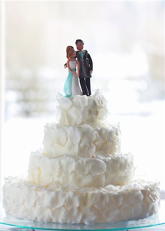 An original wedding cake decorated with white rose petals and a bridal couple in marzipan Stock Photo - Premium Royalty-Free, Code: 659-07028419