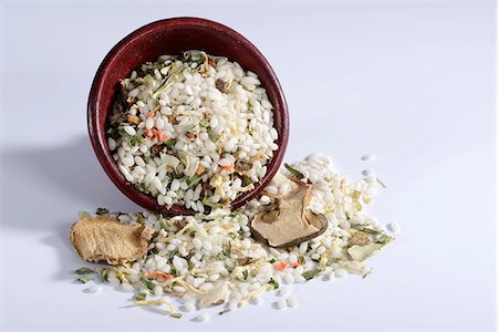 simsearch:659-06306661,k - Vialone Nano risotto rice with dried porcini mushrooms, carrots, leek, celery, chives, tomatoes and peppers with a ceramic dish Foto de stock - Sin royalties Premium, Código: 659-07028516