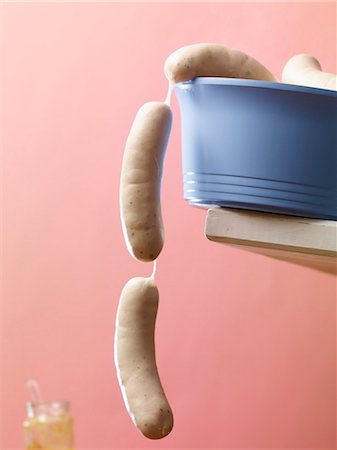 simsearch:659-06155116,k - Raw white sausages hanging over the edge of a blue plastic bowl Foto de stock - Royalty Free Premium, Número: 659-07028750