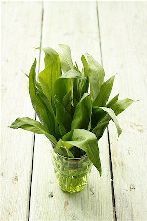 Fresh wild garlic leaves in a water glass on a wooden surface Fotografie stock - Premium Royalty-Free, Codice: 659-07028821