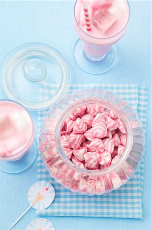 A jar of pink and white striped sweets, and a strawberry milkshake with marshmallows Stock Photo - Premium Royalty-Free, Code: 659-07028854