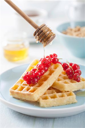 Waffles with redcurrants being drizzled with honey Stock Photo - Premium Royalty-Free, Code: 659-07028882