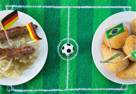 symbol - Sausages with cabbage (Germany) and salgadinhos (Brazil) with football-themed decoration Foto de stock - Sin royalties Premium, Código: 659-07028907