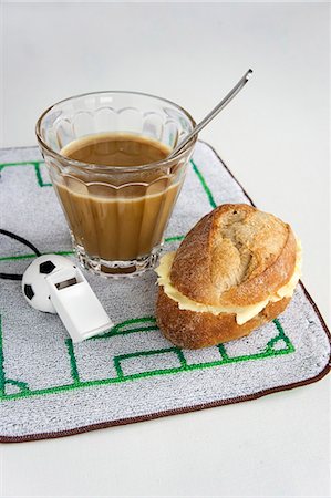 A breakfast of coffee and a bread roll with football-themed decoration Photographie de stock - Premium Libres de Droits, Code: 659-07028923
