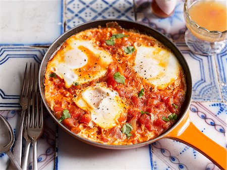 español (lugares y cosas) - Huevos rancheros with tomatoes, with a glass of orange juice Foto de stock - Sin royalties Premium, Código: 659-07029026