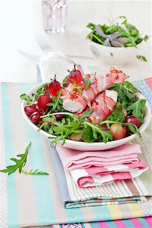 Chicken fillet wrapped in bacon on a bed of rocket with grapes Photographie de stock - Premium Libres de Droits, Code: 659-07029035