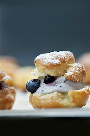 profiterole cake - A profiterole filled with quark and blueberries Stock Photo - Premium Royalty-Free, Code: 659-07029040