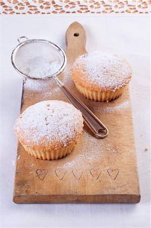 Vanilla muffins with icing sugar on a wooden board Foto de stock - Sin royalties Premium, Código: 659-07029043