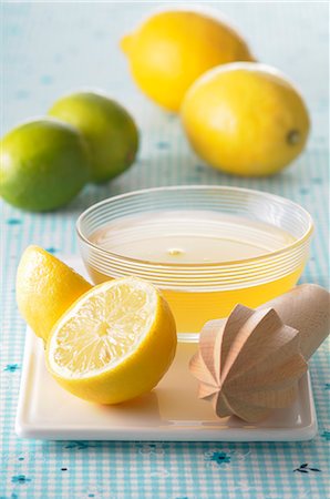 spremiagrumi a mano - Lemon juice in a small dish, a lemon squeezer and citrus fruit Fotografie stock - Premium Royalty-Free, Codice: 659-07068645