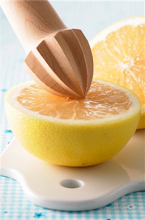 presse-agrumes - A halved grapefruit with a wooden lemon squeezer Photographie de stock - Premium Libres de Droits, Code: 659-07068669