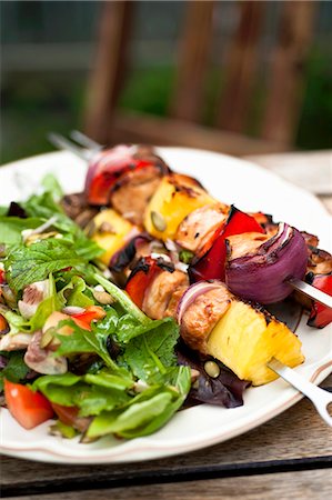 Barbecued chicken kebabs with salad on a garden table Photographie de stock - Premium Libres de Droits, Code: 659-07068745