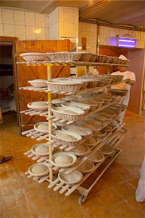 simsearch:659-06307635,k - A baker pushing a trolley loaded with unbaked bread in baking baskets Foto de stock - Sin royalties Premium, Código: 659-07068791