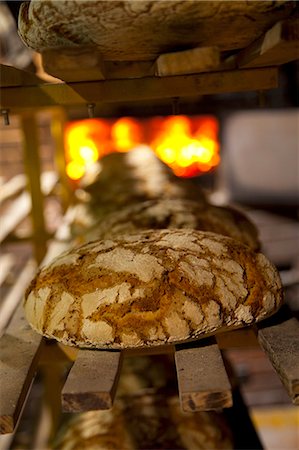 simsearch:659-08906487,k - Freshly baked loaves on a shelf in front of the wood-fired oven at the bakery Foto de stock - Sin royalties Premium, Código: 659-07068801