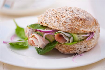 A sandwich filled with spinach, prosciutto, cucumber and onions Photographie de stock - Premium Libres de Droits, Code: 659-07068844