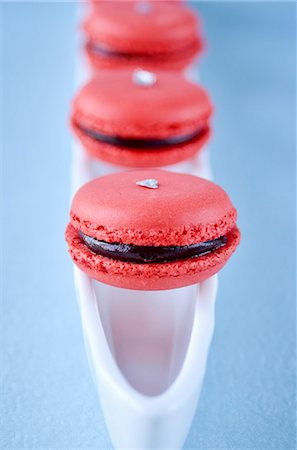 Raspberry macaroons with chocolate filling on a white dish with a blue background Stock Photo - Premium Royalty-Free, Code: 659-07068867