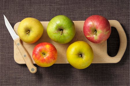 Assorted apples on a chopping board with a knife Stock Photo - Premium Royalty-Free, Code: 659-07068953