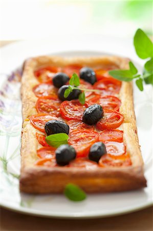 simsearch:659-07069168,k - Puff pastry tart with cherry tomatoes, olives and oregano Stock Photo - Premium Royalty-Free, Code: 659-07069166