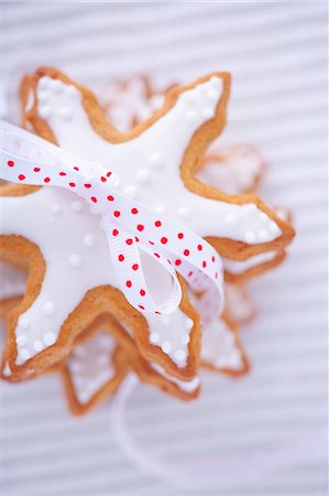 Pile of gingerbread stars garnished with icing and tied with bow Photographie de stock - Premium Libres de Droits, Code: 659-07069209