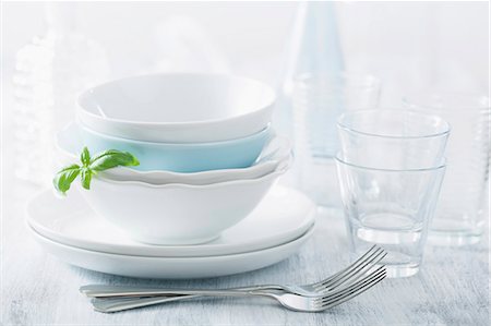dishware - Stacked dinner bowls and plated, drinking glasses and forks Stock Photo - Premium Royalty-Free, Code: 659-07069253