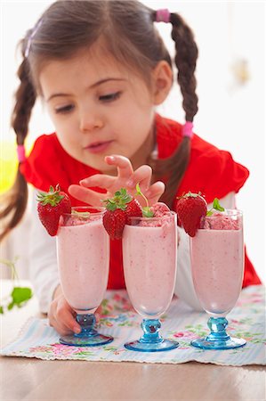 foods kids - A girl with three strawberry milkshakes Stock Photo - Premium Royalty-Free, Code: 659-07069395