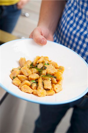 simsearch:659-07597829,k - A man serving squash gnocchi with sage (Italy) Stock Photo - Premium Royalty-Free, Code: 659-07069404