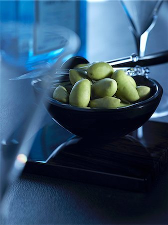 A bowl of green olives between martini glasses Stock Photo - Premium Royalty-Free, Code: 659-07069435