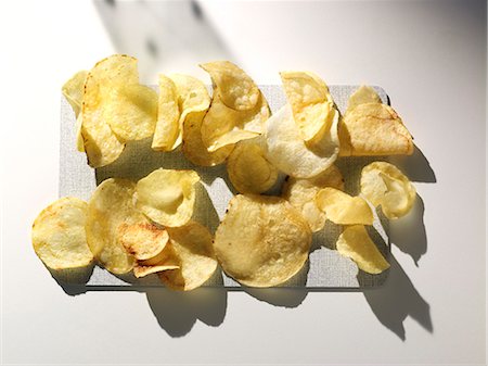 potatochips - Potato crisps on a cutting board (view from above) Stock Photo - Premium Royalty-Free, Code: 659-07069441