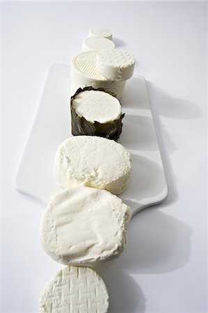 simsearch:400-03928596,k - Assorted types of fresh goat's cheese laid out in a row Foto de stock - Royalty Free Premium, Número: 659-07069464