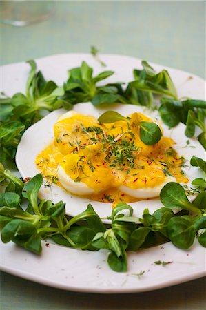 safran - Halved boiled eggs with mayonnaise and cheese sauce, garnished with lamb's lettuce, saffron and cress Stockbilder - Premium RF Lizenzfrei, Bildnummer: 659-07069618