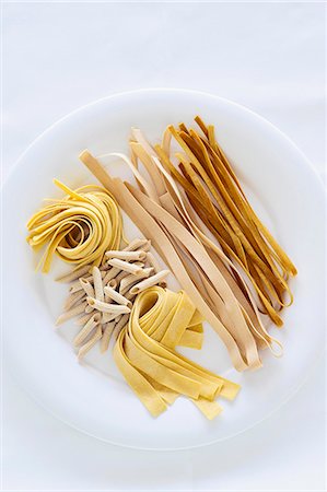 Different types of pasta on a plate against a white background Stock Photo - Premium Royalty-Free, Code: 659-07069838