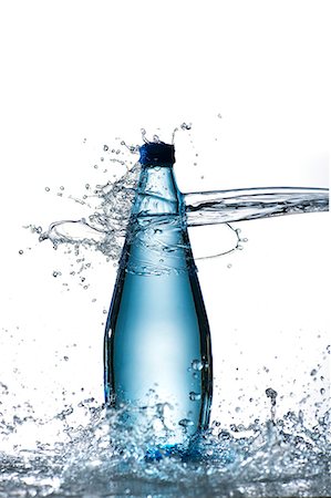 A bottle of water being hit by a jet of water Stock Photo - Premium Royalty-Free, Code: 659-07069891