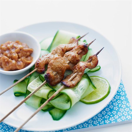 simsearch:659-07598120,k - Skewers of chicken, served with cucumber slices and a satay side-dish Foto de stock - Sin royalties Premium, Código: 659-07597059