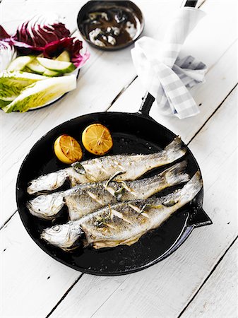 Three panfried whole bass, served in a cast-iron pan Photographie de stock - Premium Libres de Droits, Code: 659-07597068