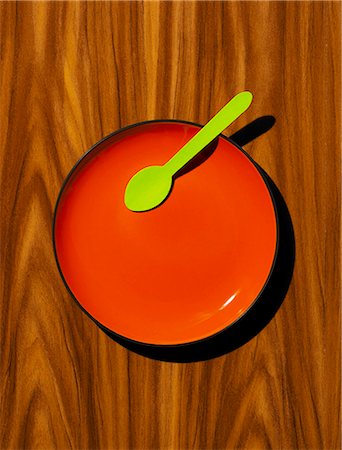 Red plate, with green wooden spoon on a wood effect background Photographie de stock - Premium Libres de Droits, Code: 659-07597060