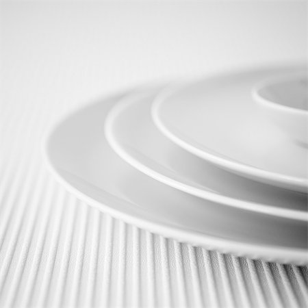 simsearch:659-06153779,k - Closeup of a stack of three white plates and a small dish Photographie de stock - Premium Libres de Droits, Code: 659-07597061