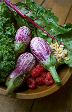 Striped aubergines, raspberries, salad and pine nuts in a wooden bowl Stock Photo - Premium Royalty-Free, Code: 659-07597199